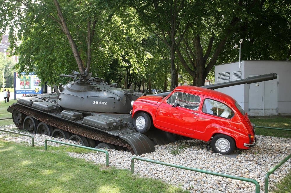Spomen-obilježje „Crveni Fićo“, postavljeno 2011. na istom raskrižju — nagnuti tenk T-55 i crvena Zastava 750 kao trajni podsjetnik na obranu Nepokorenoga grada.